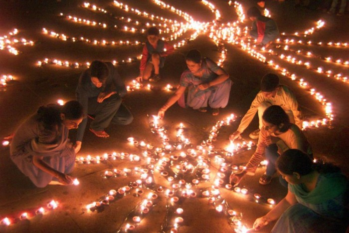 179728-indian-women-light-lamps-on-eve-of-diwali-the-hindu-festival-of-lights-e1447055328556